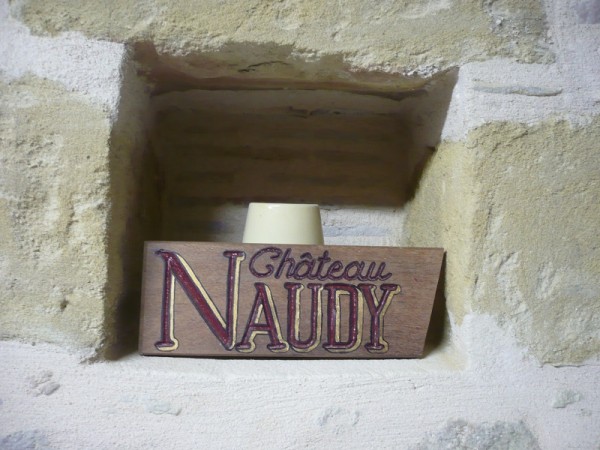 Pancarte en bois portant l'inscription : Château Naudy